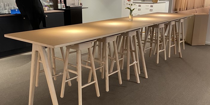Träborden Arko designade av Sami Kallio i massiv ask och träpallen SitOnMe upphängd för att underlätta lokalvård