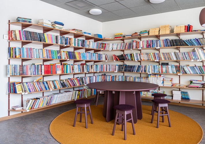 Skolbibliotekets hållbara träpelarbord Funghi i monokromt utförande Burgundy med små träpallar SitOnMe ur Lundbergs Möblers möbelkollektion